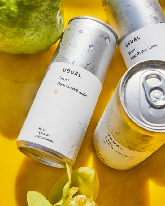 what is hard seltzer: three cans of Usual Spritz on a yellow cloth