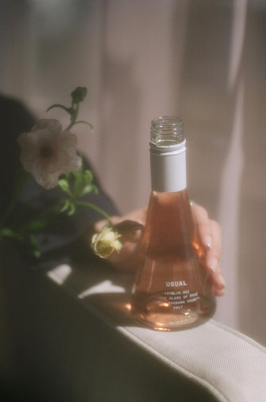 non alcoholic wine: woman holding a Usual Wines bottle