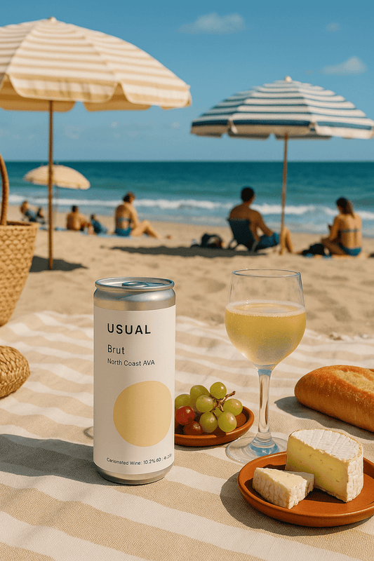 Image of the new canned Brut on a beach with some wine