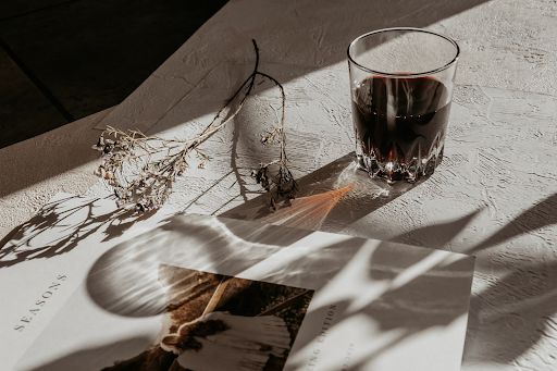 Image of a glass of wine on a white table at sunset