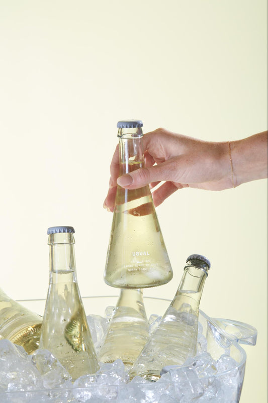 Chardonnay Wine: Person picks up bottle of Brut from ice bucket