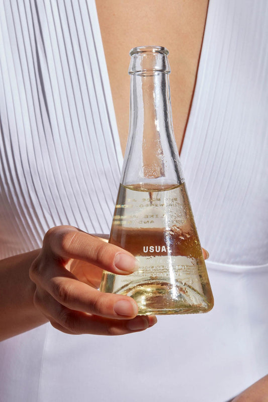 Grenache Blanc: Woman holding a Usual Wines bottle